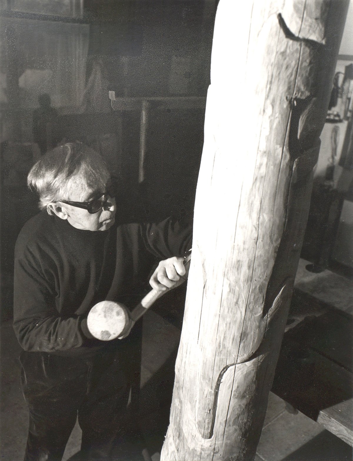 Hans Jakob Meyer in his studio in Feldmeilen, carving a wooden sculpture.